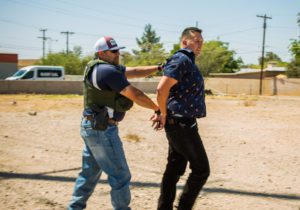 A federal agent takes Antonio Alejandro Garcia, 37, to a car to await a ride to jail following his arrest in Tucson on May 3, 2016. Garcia was wanted for a probation violation in one case and for leaving his sentencing in a separate case. (Andrew Rush/Post-Gazette)